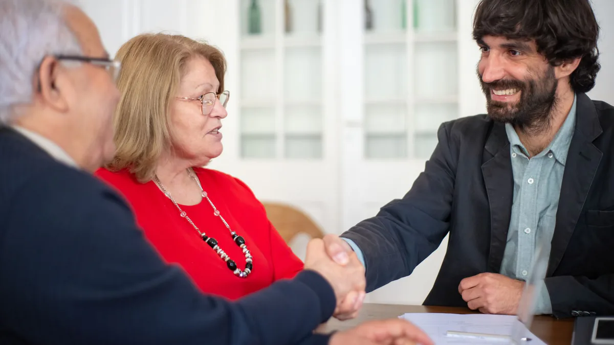 Clients shaking hands with a consultant while choosing an SEO agency
