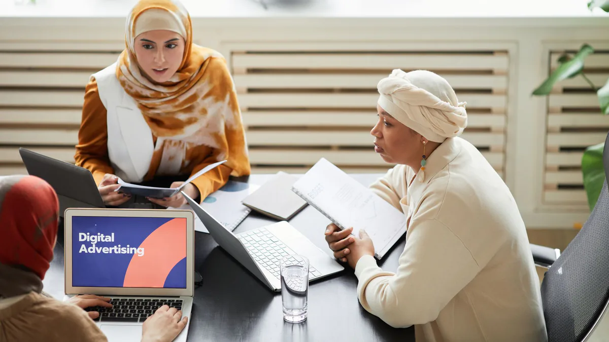 Team reviewing a digital advertising strategy on a laptop in a meeting